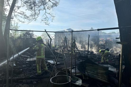 Feuerwehrmänner löschen einen Brand im Garten