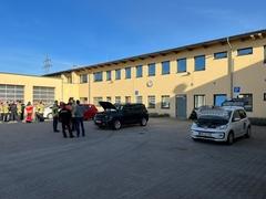 Mehrere Fahrzeuge im Innenhof der Feuerwehr mit Feuerwehrmännern davor