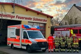 Kameraden vor dem Gerätehaus in Schmerzke mit einem RTW und Feuerwehrfahrzeug