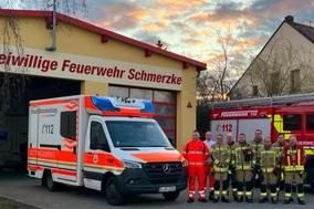 Kameraden vor dem Gerätehaus in Schmerzke mit einem RTW und Feuerwehrfahrzeug