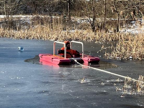 Feuerwehrmann mit Eisretter im Wasser