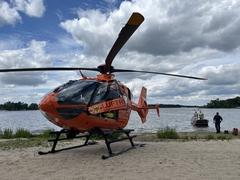Hubschrauber im Vordergrund. Hinten Wasser und Feuerwehrboot