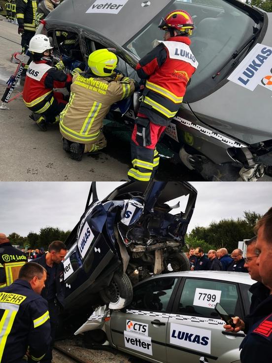 zwei Autos sind übereinander geschoben und Personen stehen drum herum