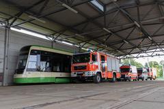 Straßenbahn im Depot und davor Feuerwehrfahrzeuge