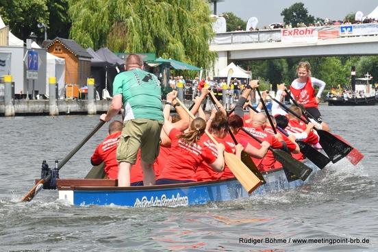 Drachenboot auf dem Wasser mit Kolleginnen und Kollegen voll besetzt