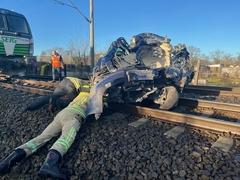 Mitarbeiter liegen am Boden am PKW auf Schiene