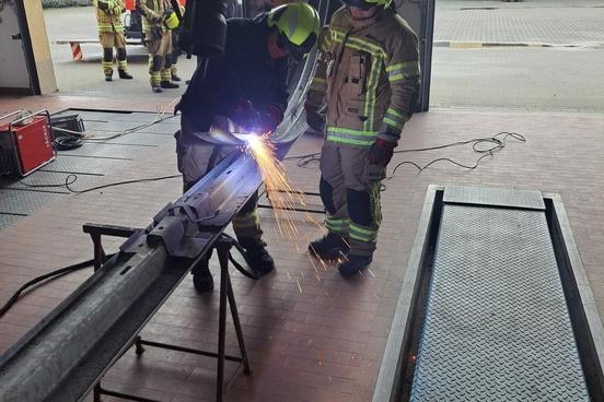 Feuerwehrmänner üben mit dem Plasmaschneidgerät in der Werkstatt