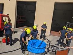 Feuerwehrmänner im Innenhof an einer großen Tonne beschäftigt