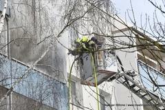 Feuerwehrmänner löschen aus Drehleiterkorb