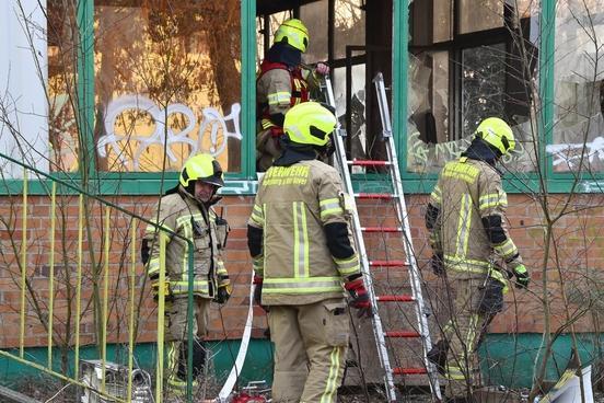 Vier Feuerwehrmänner, eine Leiter und kaputte Fenster.