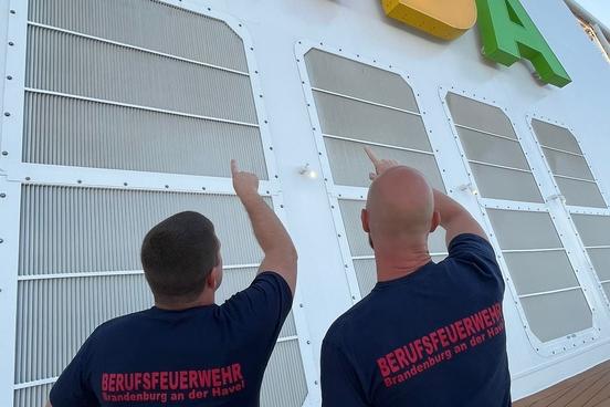 Feuerwehrmänner vor dem Logo der AIDA
