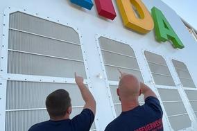 Feuerwehrmänner vor dem Logo der AIDA