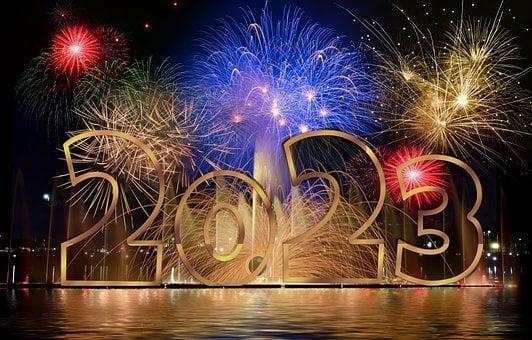 Silvesterbild 2023. Im Hintergrund explodieren Raketen. Im Vordergrund steht die Zahl 2023