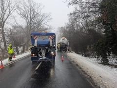 LKW am Seitenrand, Streufahrzeug vorne und ein Feuerwehrmann links