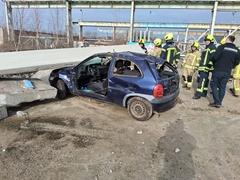PKW unter Betonklotz. Mehrere Feuerwehrmänner stehen drum rum