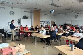 Schulungsraum mit Tischen und Menschen von Vorne