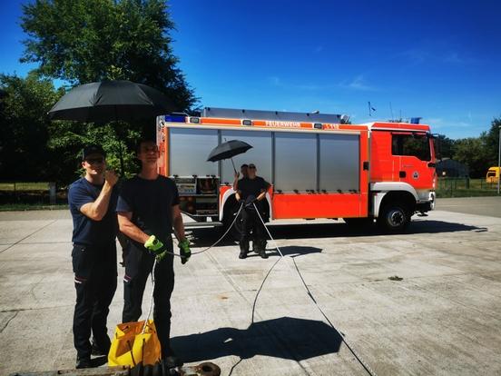 Vier Feuerwehrmänner halten eine Sicherungsleine