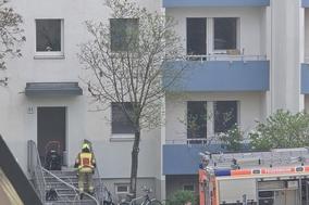 Feuerwehrleute sind an einem Mehrfamilienhaus zum Löschen